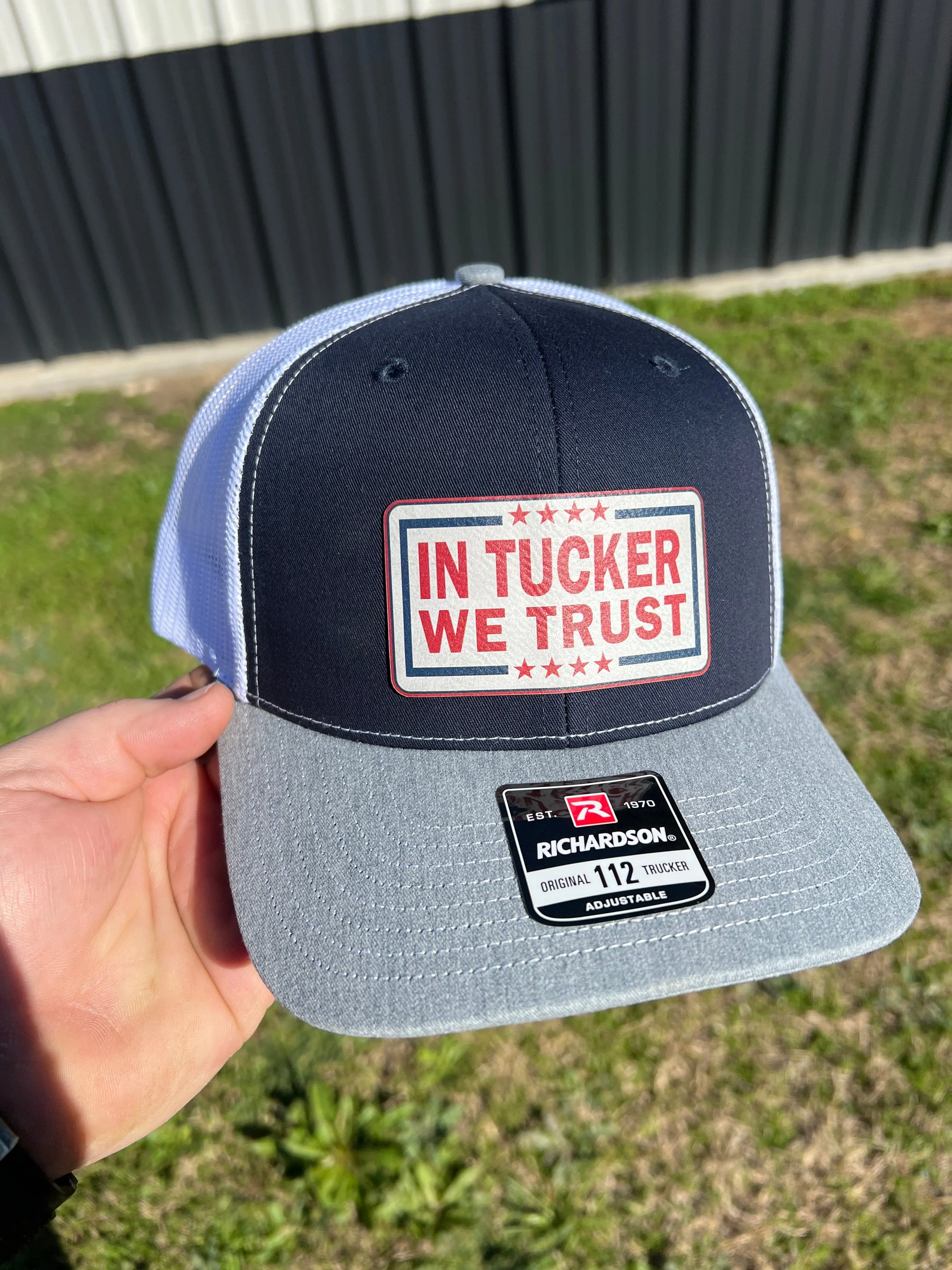 In Tucker We Trust Hat with Laser Engraved Premium Leatherette Patch on a Richardson 112 Trucker Hat.